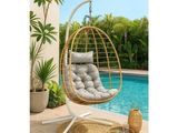 a white hanging chair next to a swimming pool