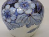 a blue and white vase with flowers painted on it