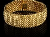 un bracelet en or sur une surface noire