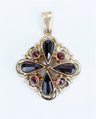 a close up of a black and red pendant on a white surface