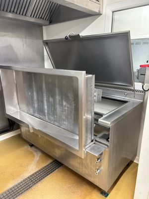 un four argenté avec une grande porte ouverte dans une cuisine