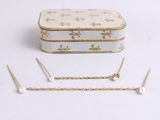 gold chain and pearl earrings with a white box on a white background