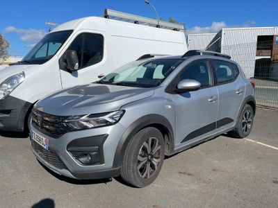 a silver car parked in a parking lot next to a white van