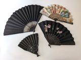 Quatre éventails chinois sont exposés sur une surface blanche