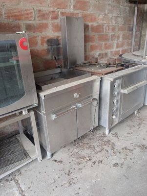 several stainless steel appliances are lined up against a brick wall