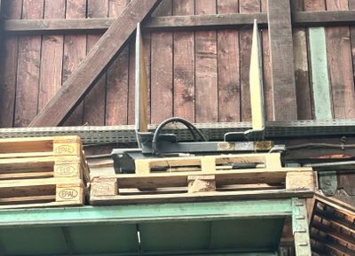 des palettes en bois empilées les unes sur les autres devant une grange