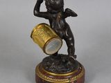 bronze figurine of a cupid playing the trumpet