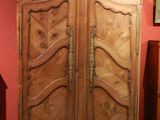 une armoire en bois dans une pièce où est accroché un tableau au mur