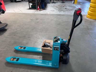 un chariot élévateur bleu transportant une caisse dans un entrepôt