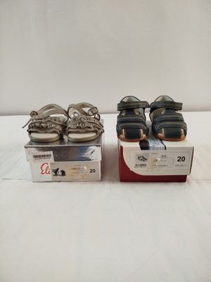 deux paires de chaussures posées sur une boîte, sur une surface blanche
