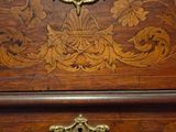a wooden chest of drawers with ornate carvings on it