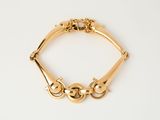 an image of a gold bracelet on a white surface