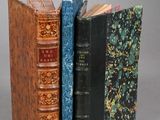 three books are stacked on top of each other on a table