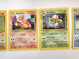 several pokemon cards are lined up on a white surface