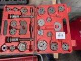 une mallette rouge contenant des outils, posée sur une table