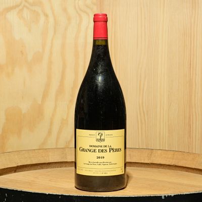 a bottle of wine sitting on top of a barrel