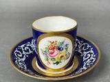 a close up of a cup and saucer on a table