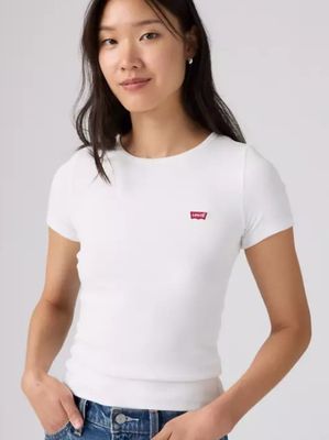 La femme porte un t-shirt blanc et un jean.