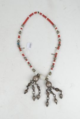 a close up of a necklace on a white surface