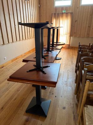 de nombreuses chaises et tables dans une pièce aux murs en bois