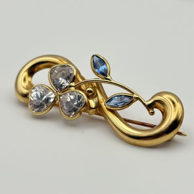 Broche en or 18K sertie de pierres synthétiques.