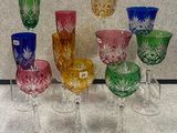 de nombreux verres en cristal de différentes couleurs posés sur une table
