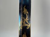 a black and gold vase with a gold design on it
