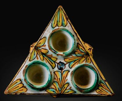 a triangle shaped object with three cups in it