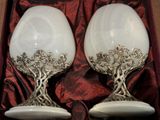 deux verres à vin posés dans une boîte sur un tissu rouge
