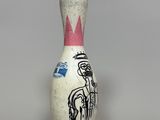 a small bowling pin with a drawing on it