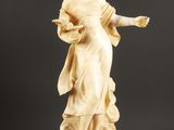 une statue représentant une femme tenant un oiseau, sur fond noir