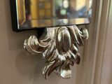 un miroir accroché au mur au-dessus d'un miroir