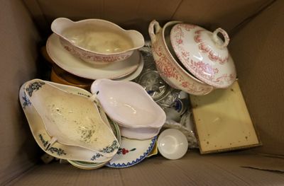 a cardboard box filled with assorted dishes and saucers