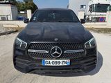La Mercedes GLE est garée sur un parking devant un immeuble.