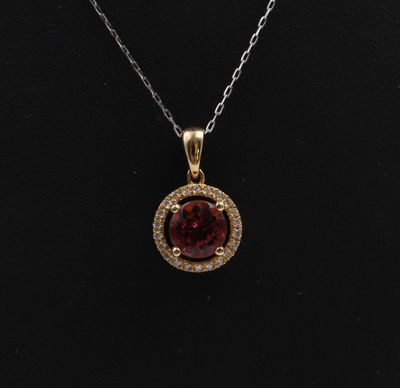 a necklace with a red stone surrounded by white diamonds