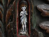 a wooden carving of a man holding a staff