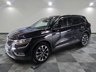 Un SUV noir est garé sur un sol à damier dans un garage.