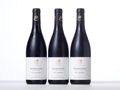 trois bouteilles de vin rouge posées sur une table