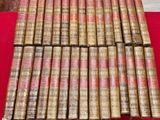 a stack of old books sitting on top of a red table