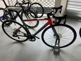 many bikes that are parked in a room together