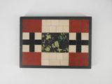 a close up of a tile on a white surface with a red and black border