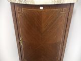 une armoire d'angle au plateau en marbre, placée dans un coin de la pièce