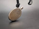 a small metal object hanging from a cord on a table