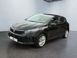 La voiture noire est garée dans une grande pièce au sol noir.