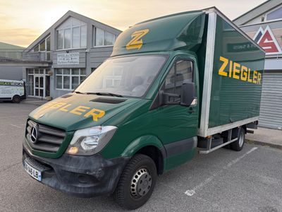 a green delivery truck parked in front of a building