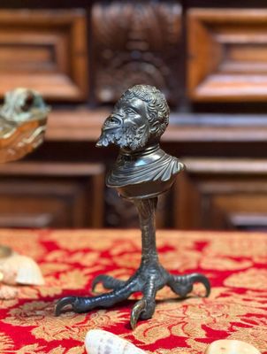 une statue représentant un homme assis sur une table, à côté de coquillages