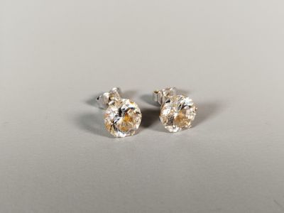 a pair of diamond earrings on a white surface