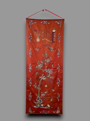 a red wall hanging with birds and flowers on it