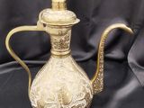 une théière ancienne en laiton ornée d'un motif élaboré