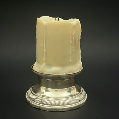 des bougies sont allumées sur un plateau en argent posé sur un fond noir